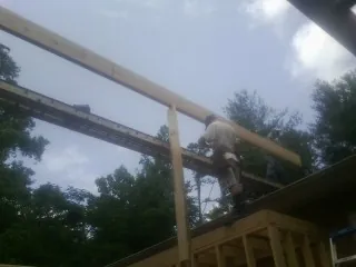 Carpenter setting a ridge beam over a new addition frame — Ice Dam Removal by Roofing Brothers in Harrington Park