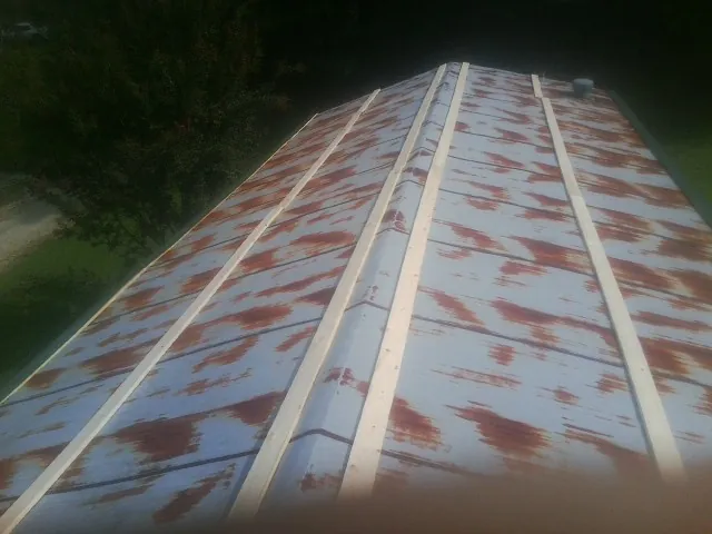 Rusted metal roof panels with new wood purlins before replacement — Storm Damage Roof Repair in Harrington Park by Roofing Brothers