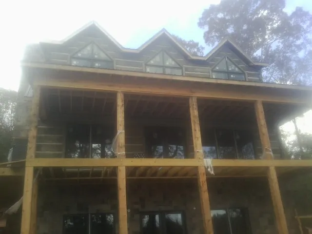 Dormers and porch framing on a large log home under construction — Roof Coating work by our crew in Harrington Park